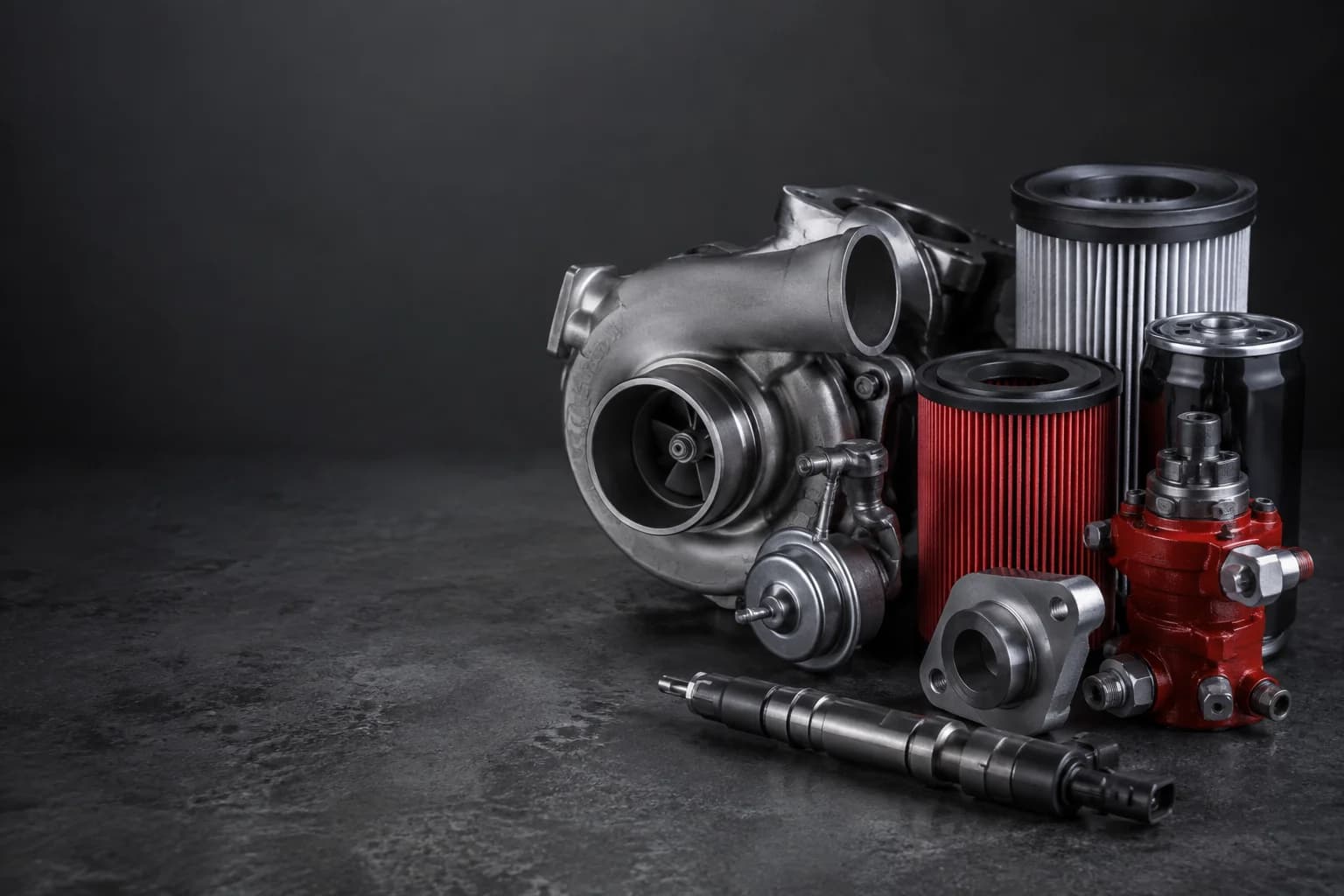 Heavy-duty turbocharger, fuel-system components and filters arranged on an industrial work surface.